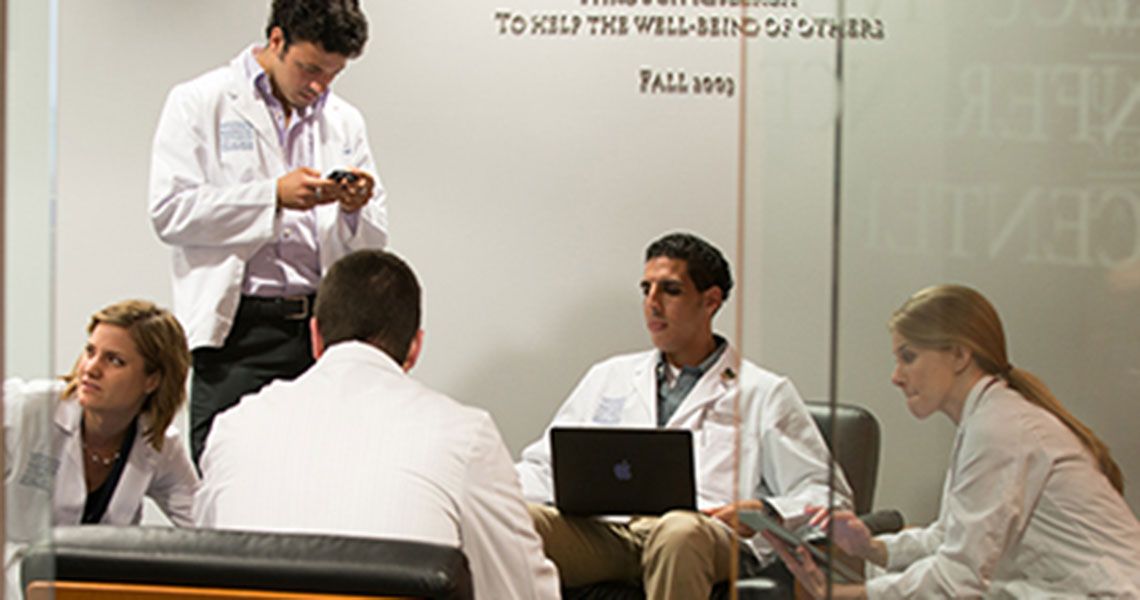 Five medical students sitting in a room 