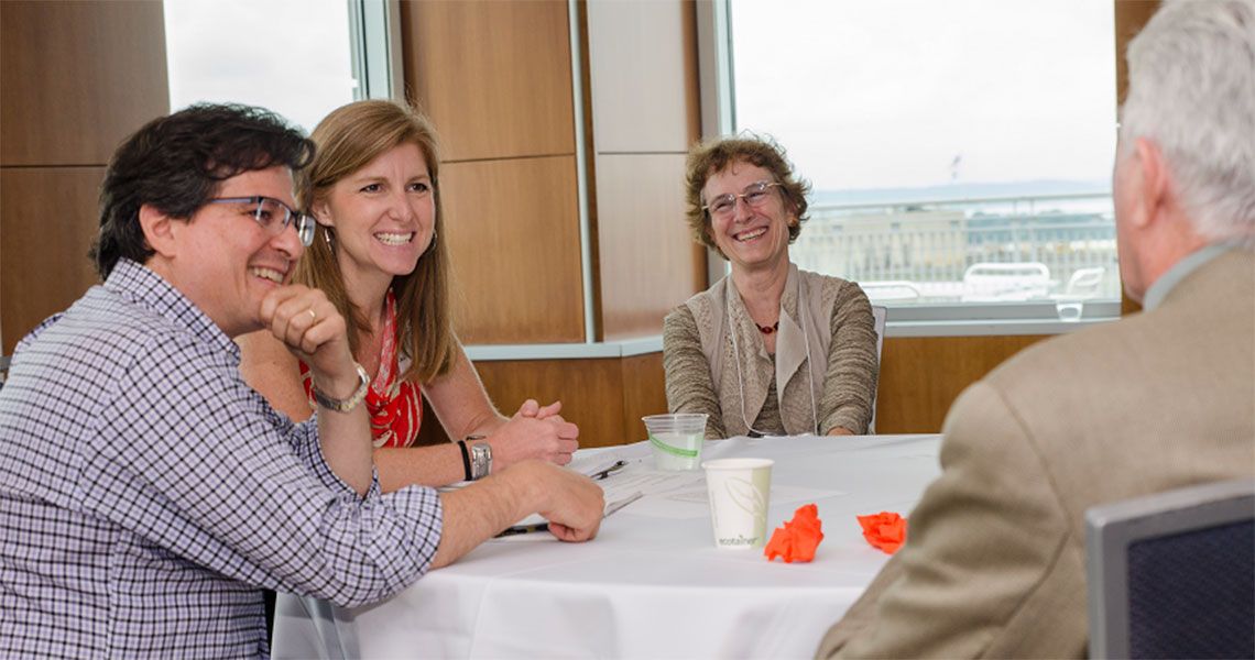 Christina Puchalski, M.D., center, chats with GWish Summer Institute participants at at a table