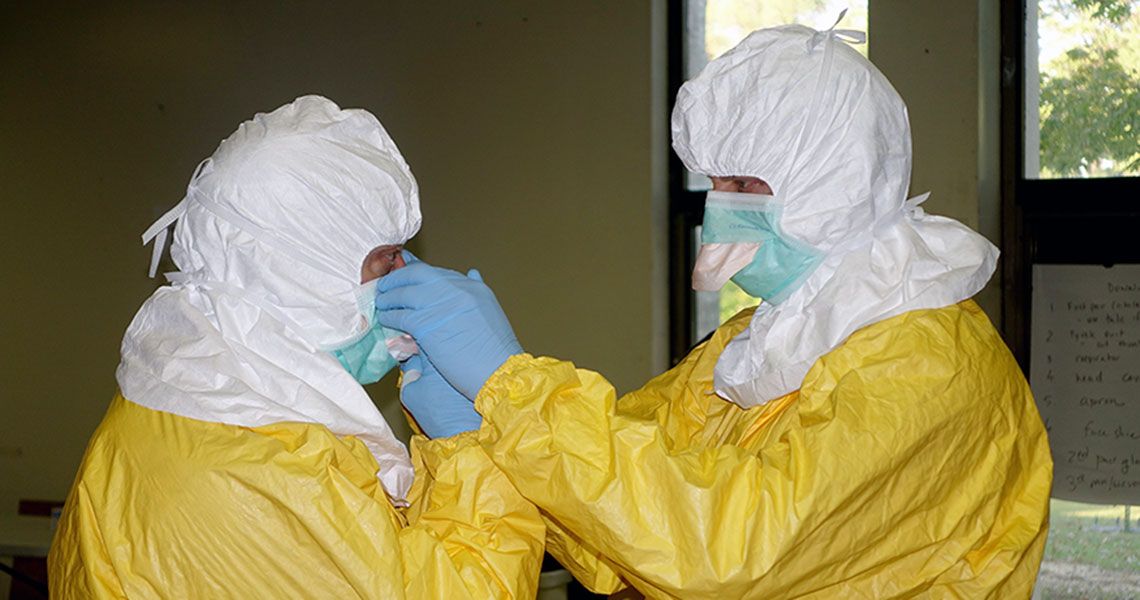Two people in yellow and white Personal Protective Equipment