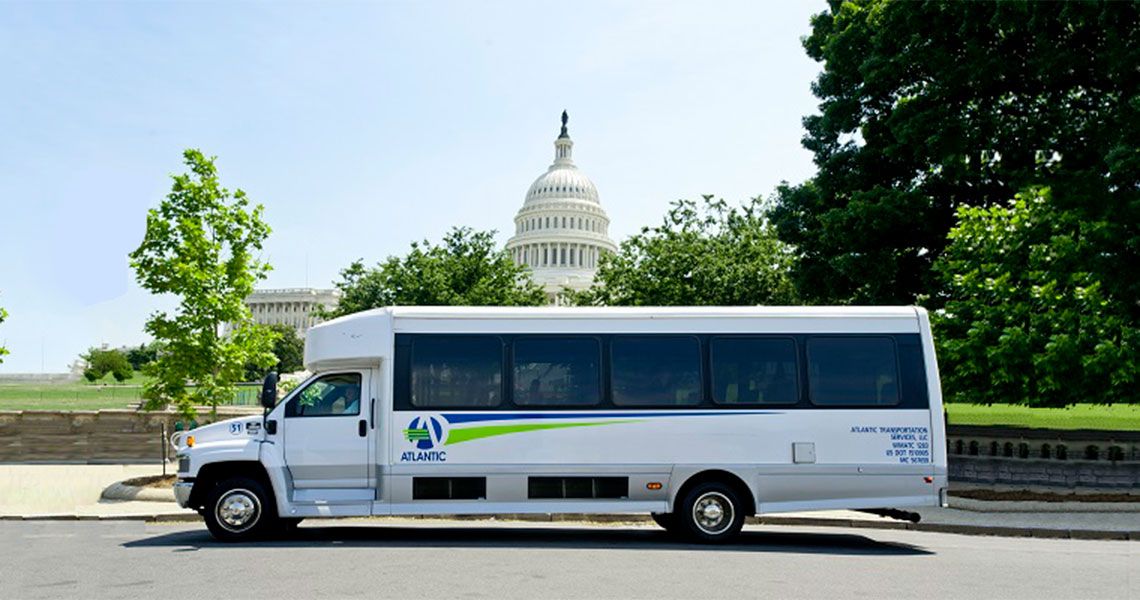 A shuttle bus parked with the U.S. Capitol seen in the distance