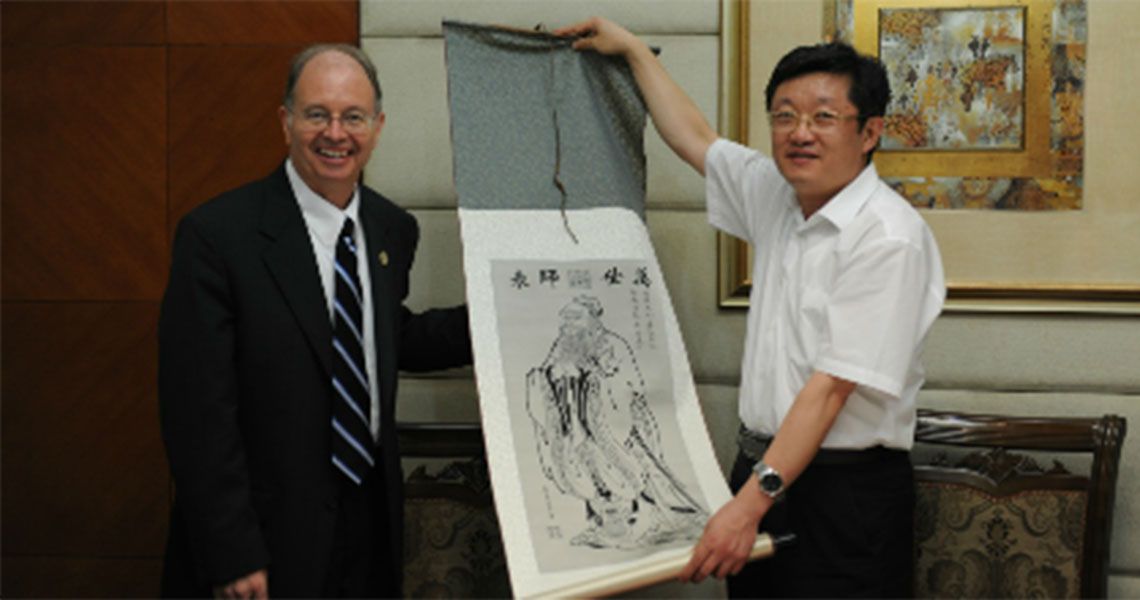 Robert G. Hawley being presented with art by another man