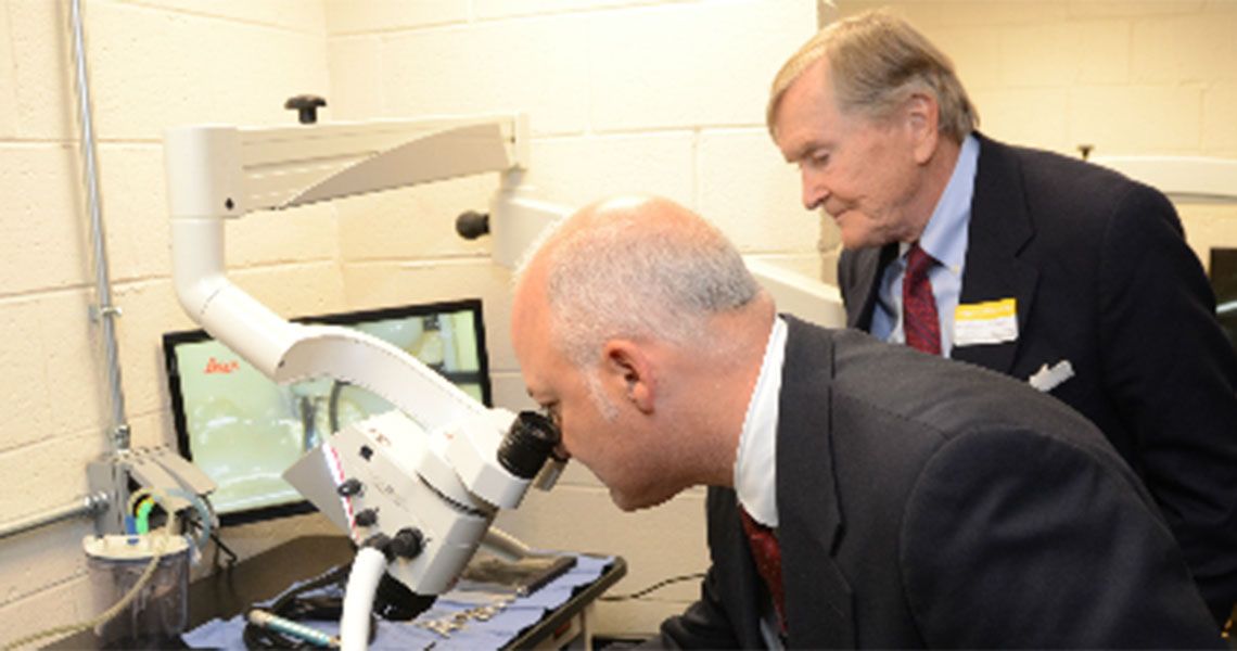Two men looking through a microscope