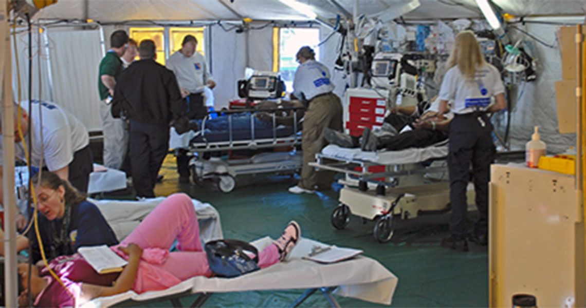 Medical personnel and patients under a medical tent