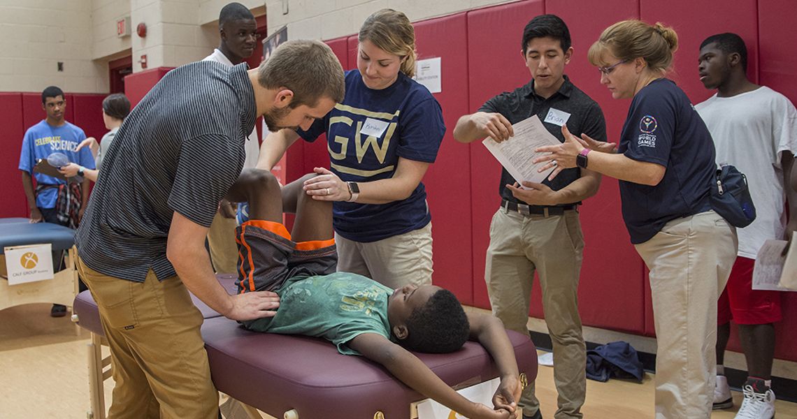 Physical Therapy students working on a person in a gymnasium