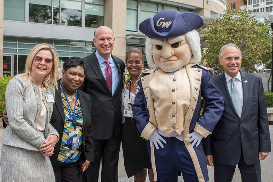 GW faculty standing with the George Washington mascot