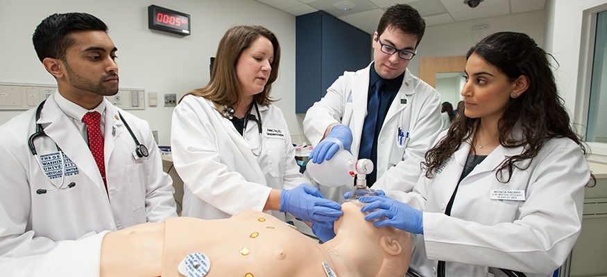 Four medical students work on a Manikin
