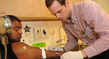 A man administers a shot into a patient's arm