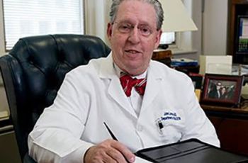 Dr. John Larsen sitting at his desk