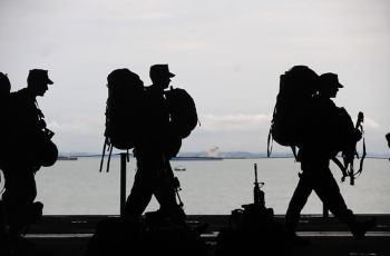 Silhouettes of soldiers walking along a walkway