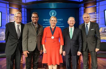 Jon C. White, MD; Christopher Bracey, JD; Barbara L. Bass, MD; GW President Mark S. Wrighton, PhD; and Anton N. Sidawy, MD stand together at the GW School of Medicine and Health Sciences