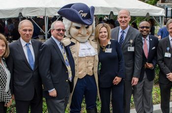 Several GW Medical faculty standing together with the George Washington mascot