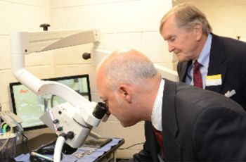 Two men looking through a microscope