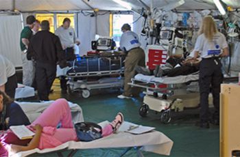 Medical personnel and patients under a medical tent