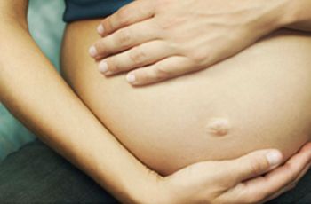 A pregnant woman clutching her exposed stomach
