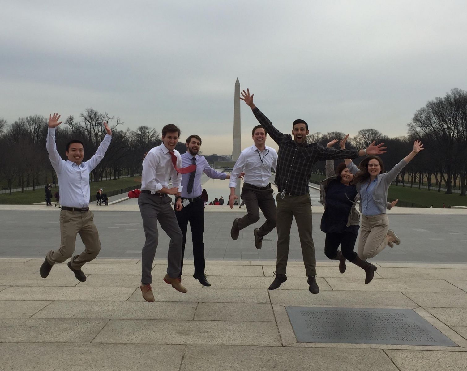 Students jumping of joy near the reflecting pool