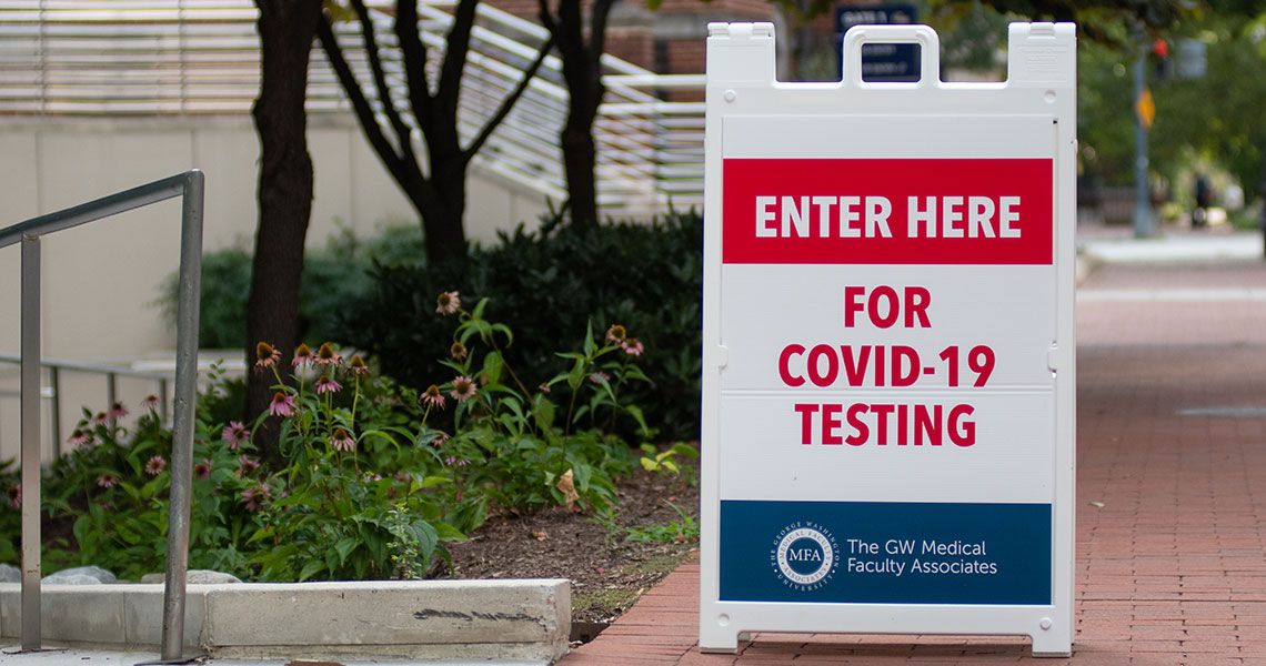 A sign on GW's campus reading 'Enter here for COVID-19 testing'