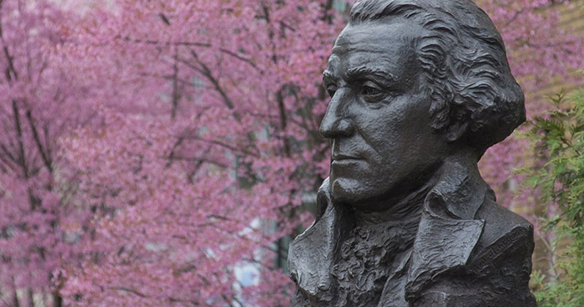 Bust of George Washington in front of cherry blossom trees