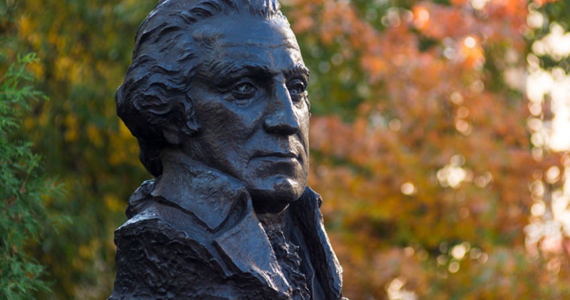 Bust of George Washington in front of autumn foliage