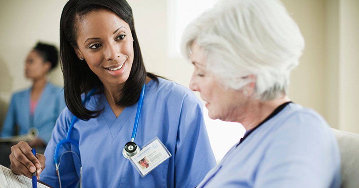 A nurse speaking with an elderly patient