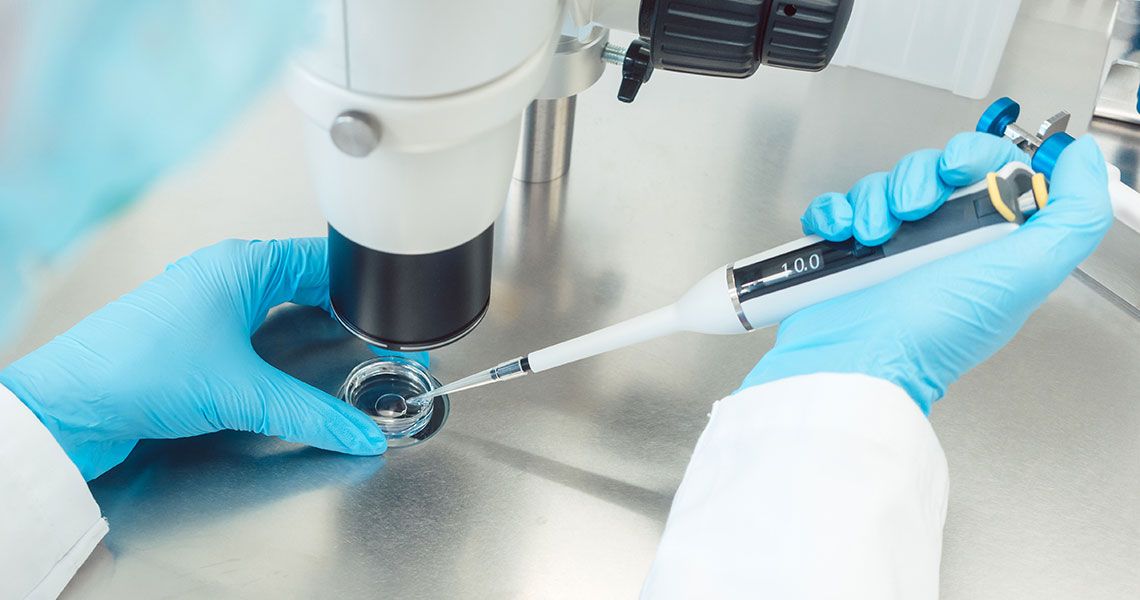 A researcher using a pipette in a lab