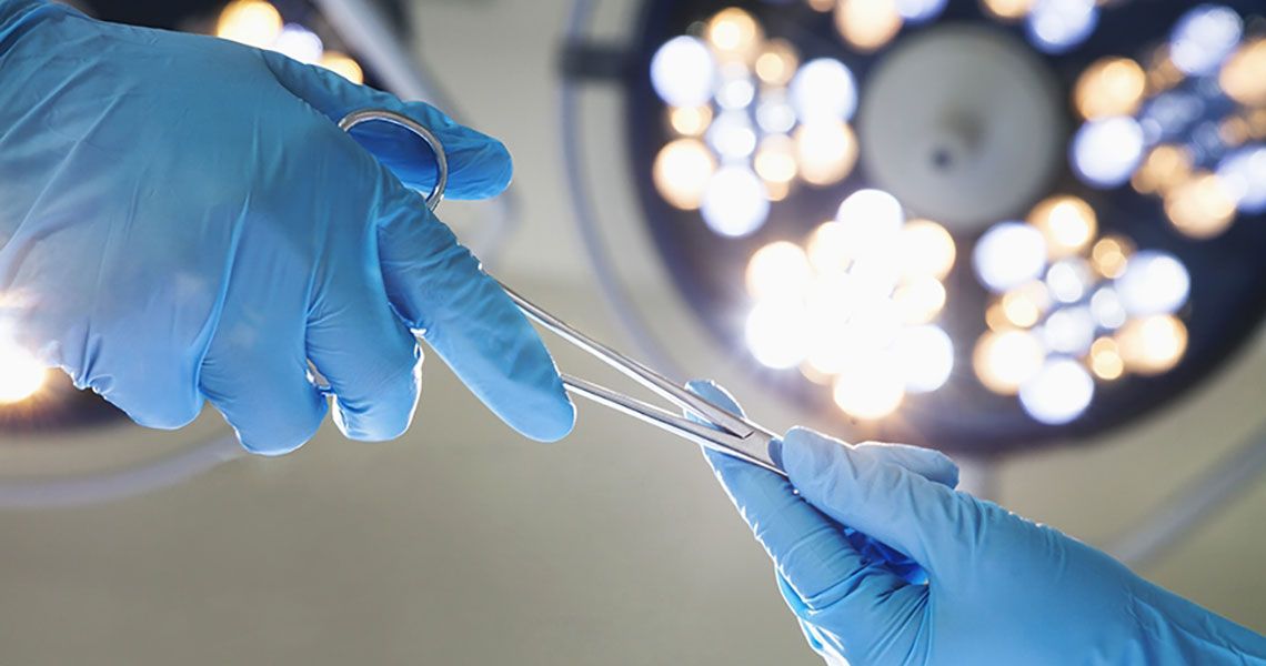 A surgeon receiving a tool in an operating room