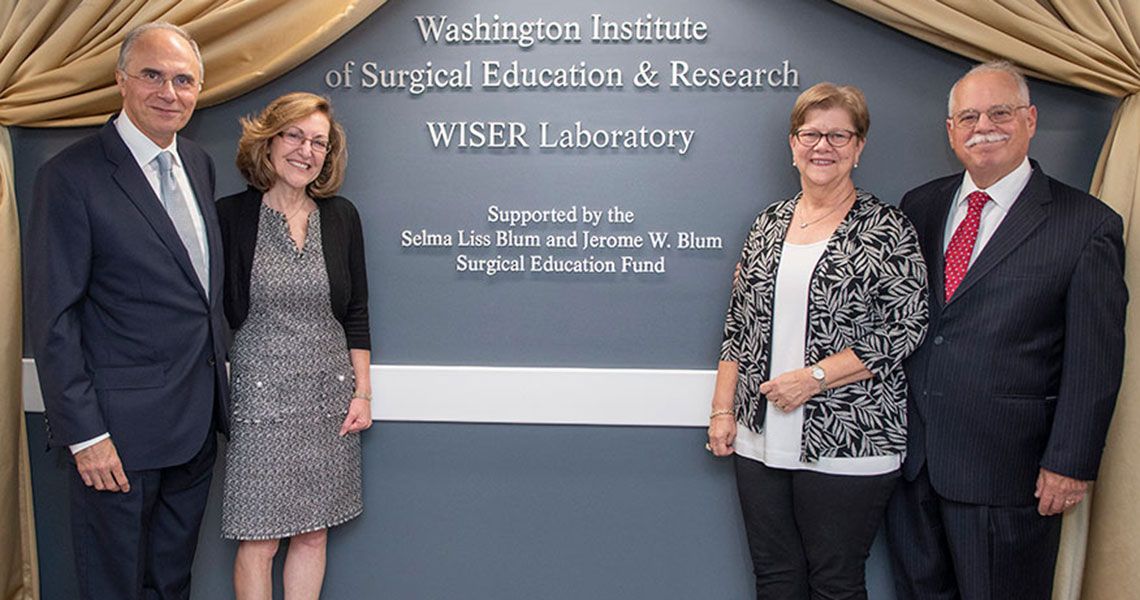 Washington Institute of Surgical Education & Research WISER Laboratory | Four GW faculty members standing by a wall