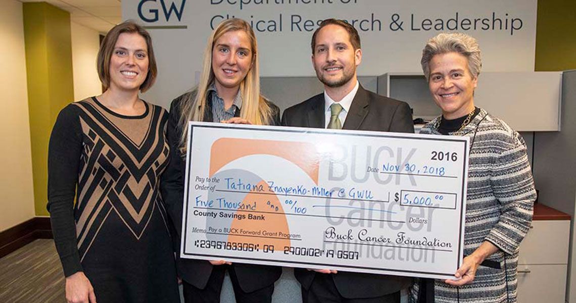 Four people holding a large Buck Cancer Foundation check for $5000