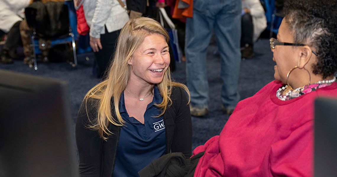 A GW volunteer smiling at a patient