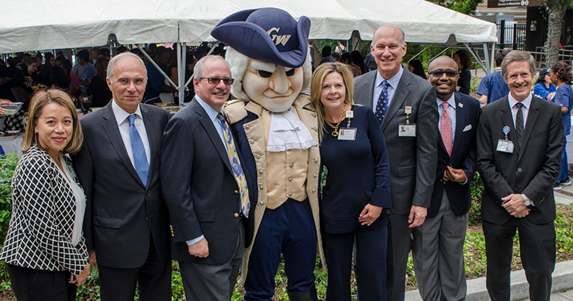 Several GW Medical faculty standing together with the George Washington mascot
