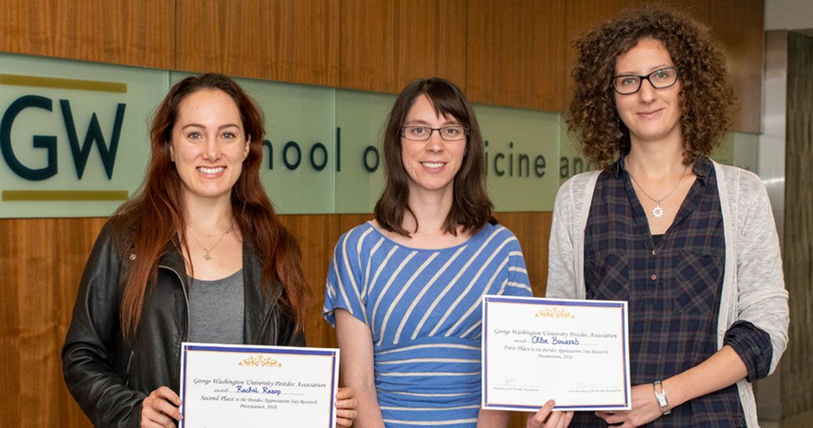 Three GW postdocs standing together holding certificates