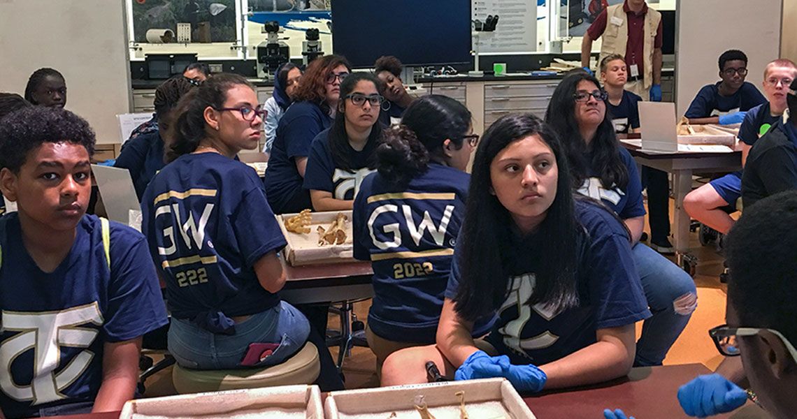 T.C. Williams High School students wearing GW shirts and sitting in a health sciences classroom