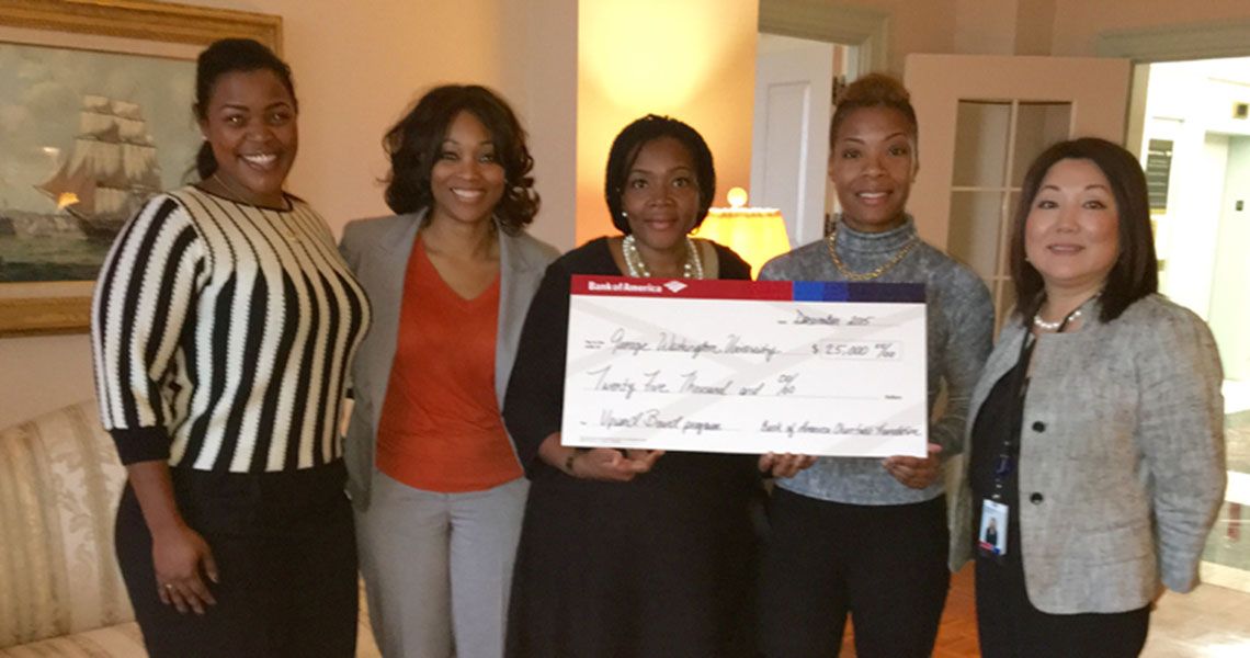 Several Upward Bound faculy standing and holding a check from The Bank of America Charitable Foundation 