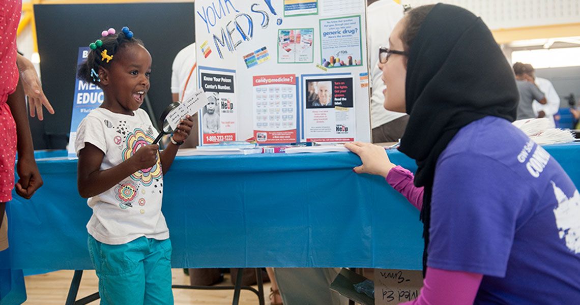 A Community Service Day volunteer interacts with a young participant