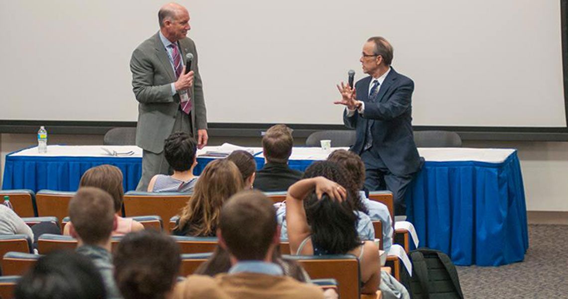 Dean Akman and Bopper Deyton speak in front of a class