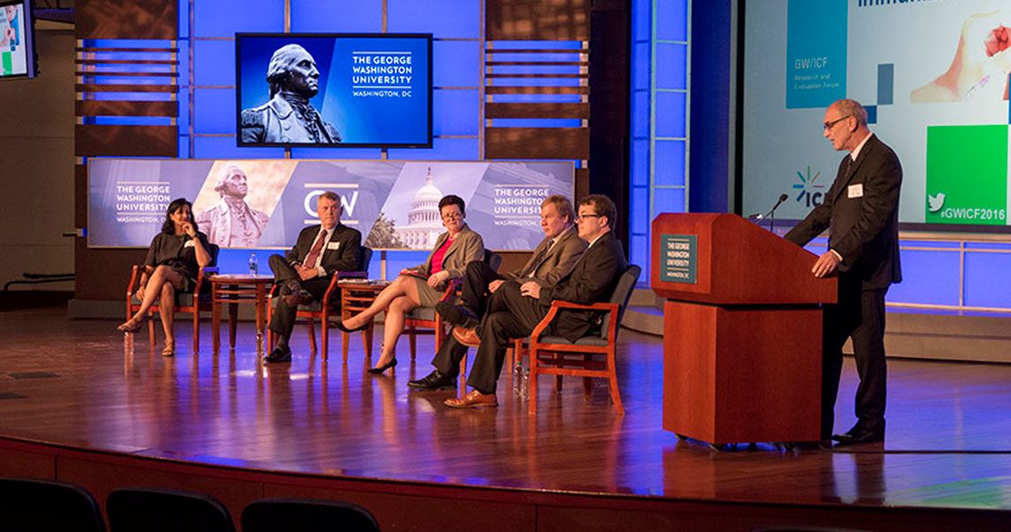 GW faculty sitting in chairs on a stage