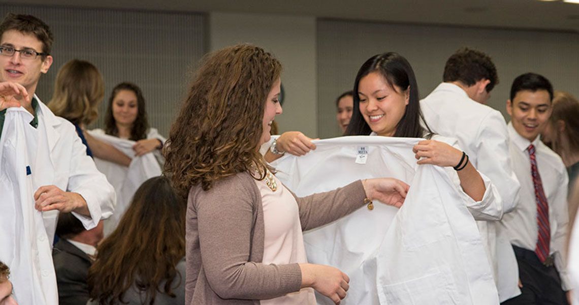 Physical Therapy students putting on white coats