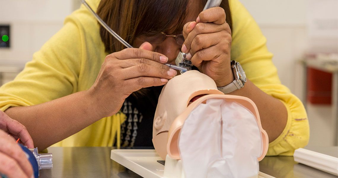 A volunteer with Operation Smile practices on a dummy in the CLASS Center at GW