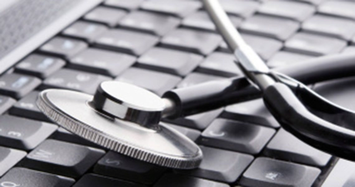 A stethoscope resting on a computer keyboard