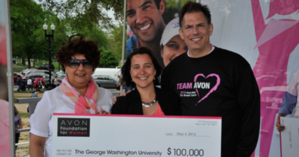 Mandi Pratt-Chapman, holding a $100,000 grant from the Avon Foundation next to two other people