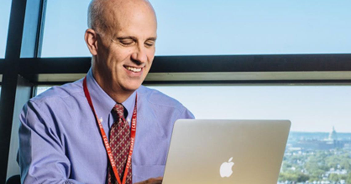 Dr. Stephen J. Teach using a Macbook laptop