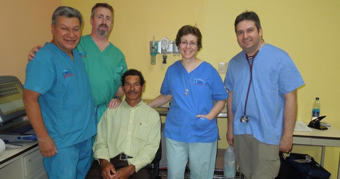 Doctors in scrubs standing with a patient in Honduras