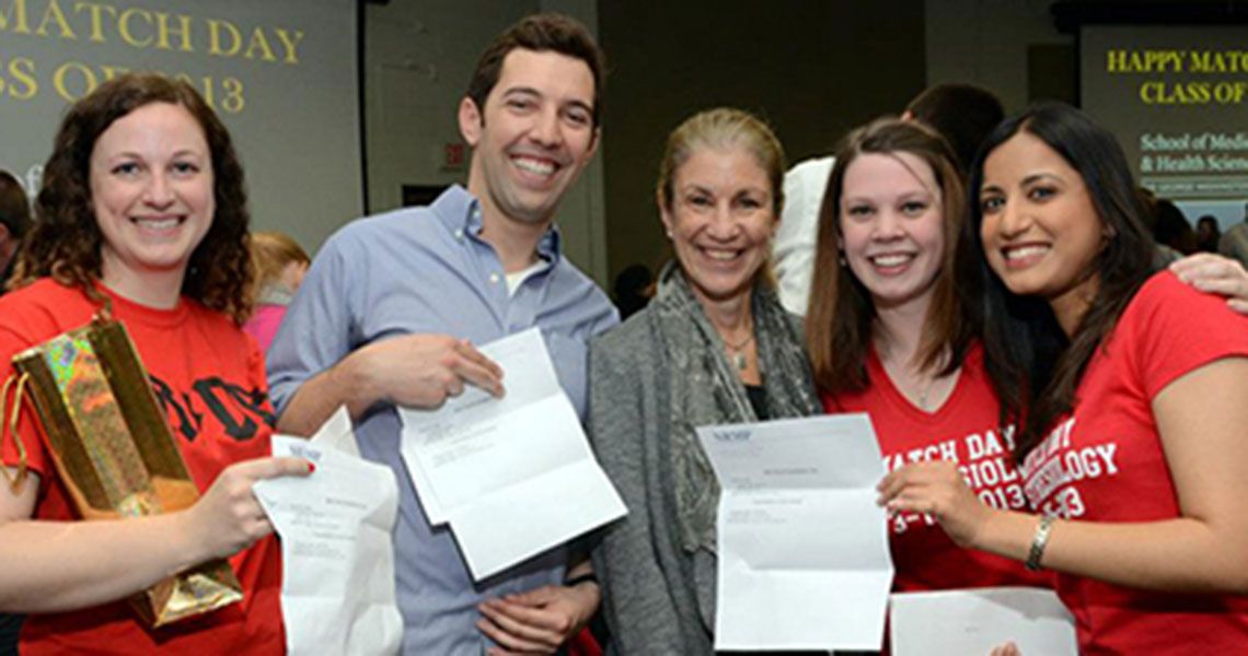 Students pose with match letters and Dean Goldberg
