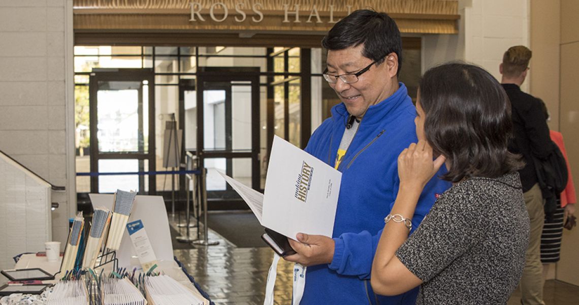 A man and a woman are shown during alumni check-in inside Ross Hall