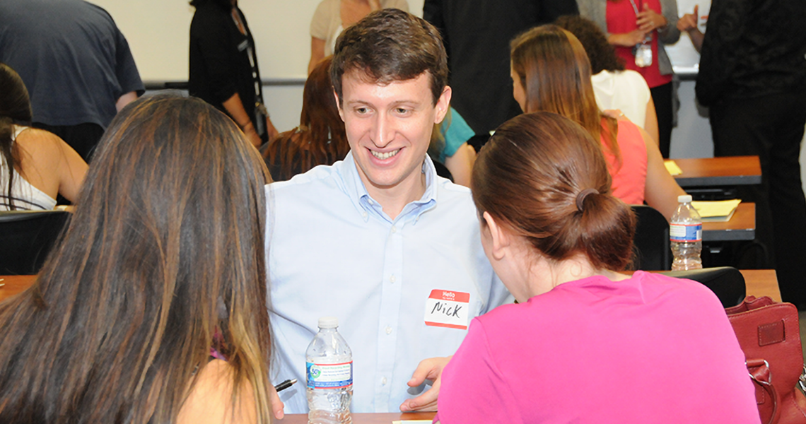 Students sitting at a table smiling