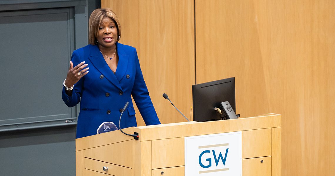Dr. Nesbitt speaking at a podium at GW.