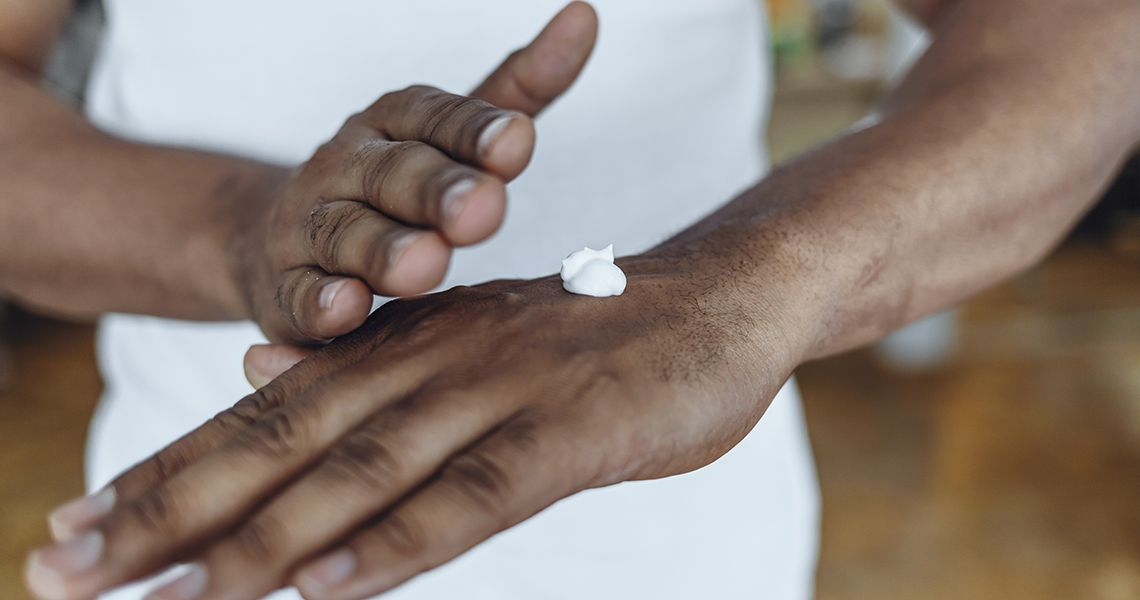 Man rubs lotion onto hands
