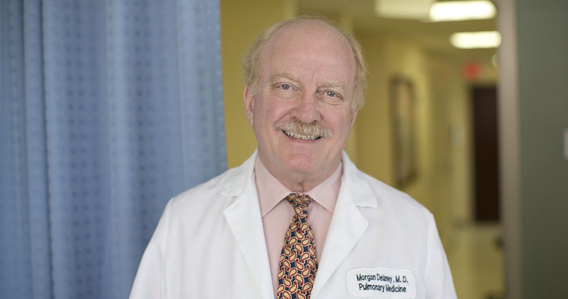Morgan Delaney in white coat standing in clinic