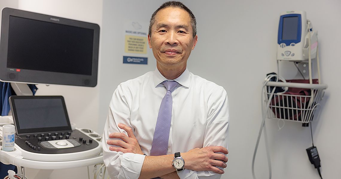 Norman Lee, PhD, in clinic space with arms crossed