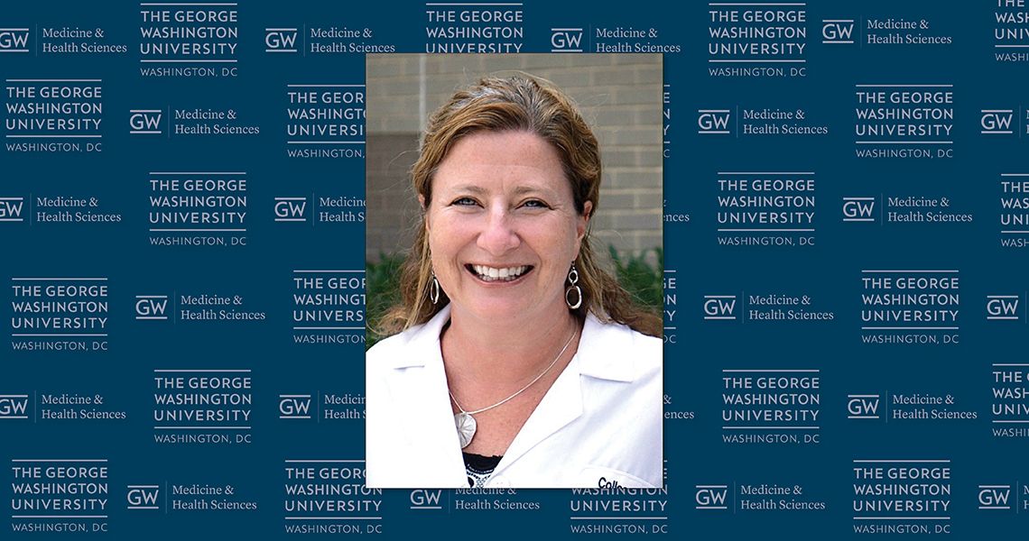 Photo, Colleen Roche, MD, in front of GW SMHS logo pattern