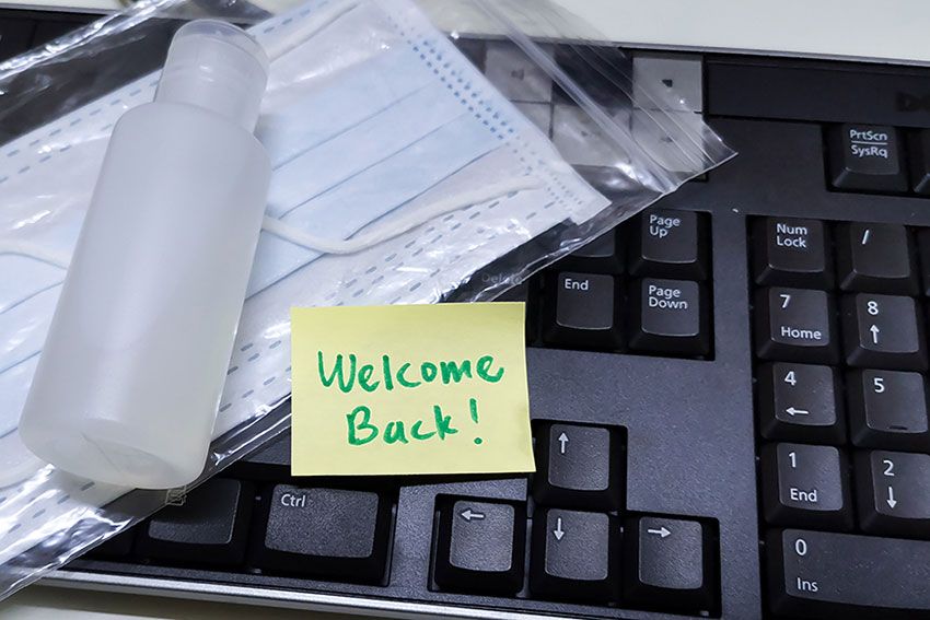 A sample bottle, a mask and a note that says 'Welcome Back!' lie on a keyboard